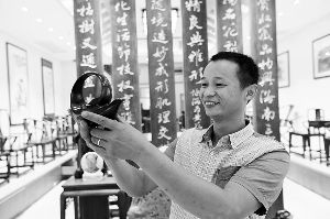 周凤炎展示他创作的曲壶。