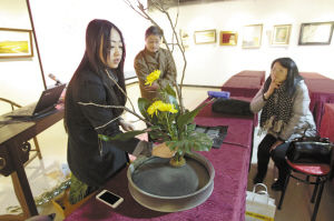 管雅在翟振辉的“茶盘”售价2000元上表演花艺。记者 王鹏 摄