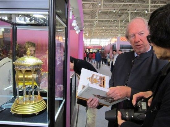 　资料图片：美国商人约翰（左）展示法国景泰蓝古董钟表。