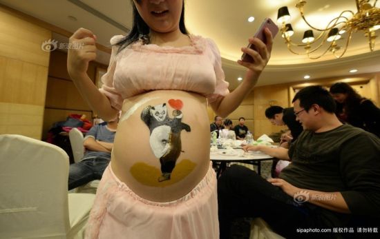 2013年10月27日，重庆市妇幼保健院，重庆孕妈彩绘大赛。一位准妈妈在肚子上画上功夫熊猫，希望孩子能生龙活虎。摄影 渝友 SipaChina
