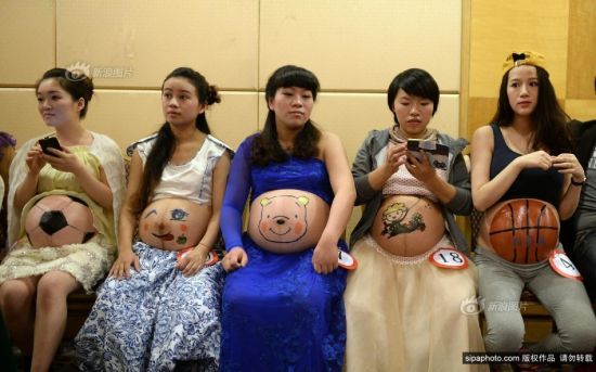 2013年10月27日，重庆市妇幼保健院，重庆孕妈彩绘大赛。准妈妈们在自己挺起的肚子上绘画各种图案，代表着对未来宝宝的祝愿。摄影 渝友 SipaChina