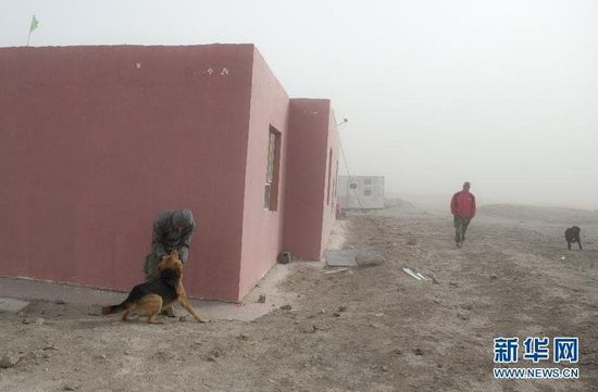 崔有生(右)和杨俊花了很长时间才在沙尘中找到了他俩走失的狗(10月28日摄)。