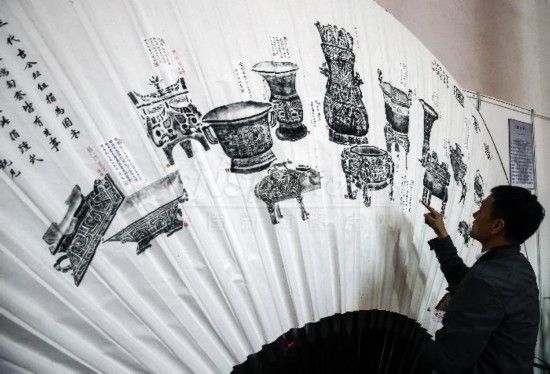 10月24日，一名观众在北京农业展览馆参观《吉金图》大扇。