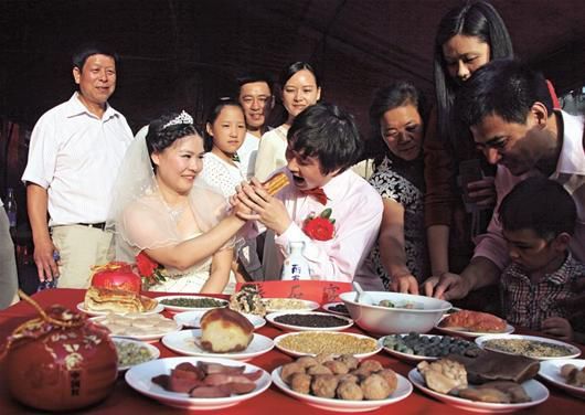 图为：新郎新娘“享受”石头宴