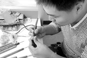 图为王千星正在聚精会神地进行雕刻。