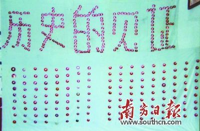 黄春生用他收藏的毛主席像章摆出了“历史的见证”五个大字。