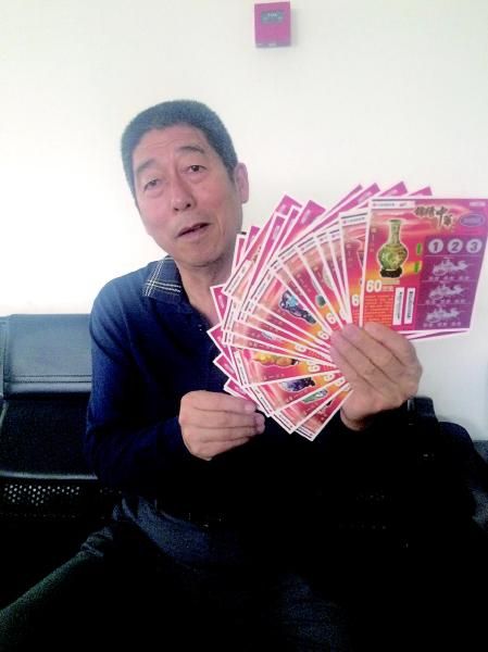 杨克勤展示自己最喜欢的彩票藏品“锦绣中华”。