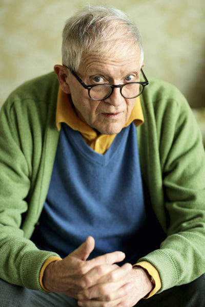 他的穿衣风格和在自画像里一样：灰色裤子、粉蓝毛衣，露出橘色的恤衫领口，最外面再搭件果绿羊毛开衫。所有颜色，看起来都像是刚从他的调色板里洒出来，极其的大卫·霍克尼。(摄影/张雷)