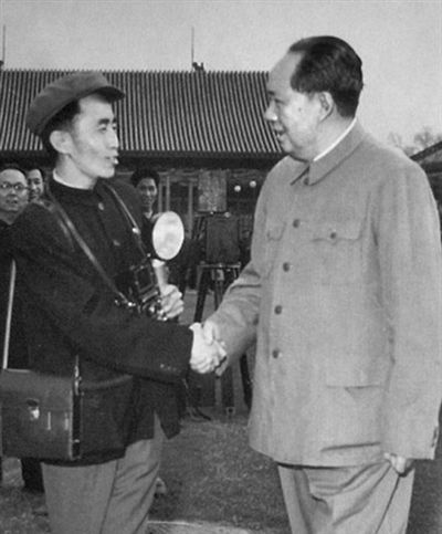 1958年，吕厚民手拿相机和毛泽东握手。