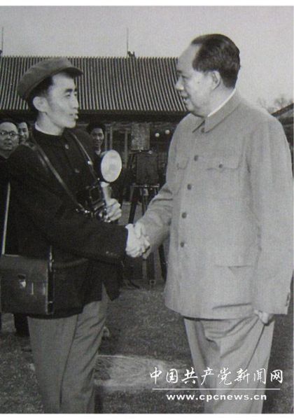 　　1958年，吕厚民手拿闪光灯、相机、挎包和毛主席握手