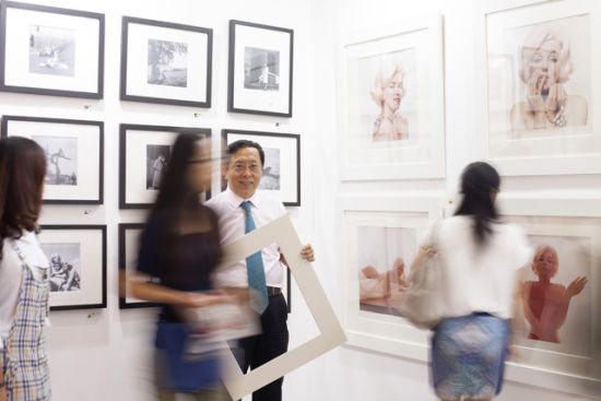 靳宏伟的新身份—世界级图片社 Sipa 的大股东。他代表 Sipa 参展的上海艺术影像展，展位的一组玛丽莲·梦露限量版彩色照片前人潮涌动（摄影：李威娜）