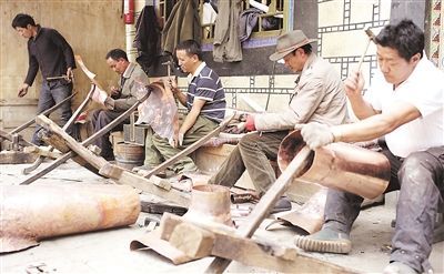 图为拉萨市八廓古城一家大院里金属手工艺者们在细心制作藏民族传统金属手工艺品。 记者 高加库 摄