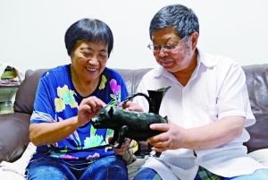 华义武　　文物鉴定副研究员　　华义武和老伴儿史润梅一起欣赏龙山黑陶猪。