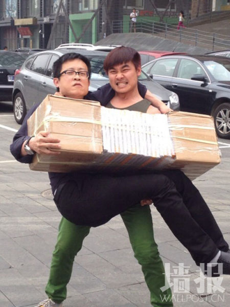 厉槟源抱起杭春晓和41本41公斤重的今日美术馆画册，共分三次抱起，计时1分20秒