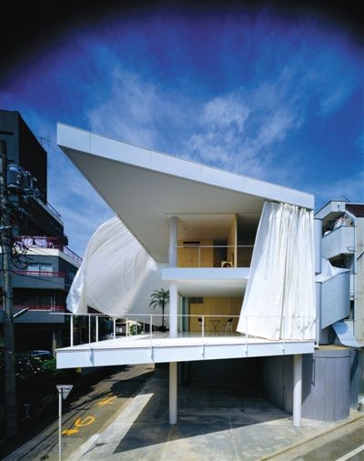 在东京的“幕墙宅”（1995年）中，沿着房子外围的白色窗帘可以打开进行空气对流，也可以在关闭后形成一个茧状内部空间。 Hiroyuki Hirai摄