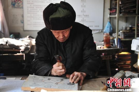 图为88岁的杨家埠木版年画代表性传承人杨洛书正在刻传统的年画“年年有鱼”。他说：“过年老百姓都图个吉利，不过这块版是专门用来观赏的，要是印画得反过来刻。” 于志君 摄