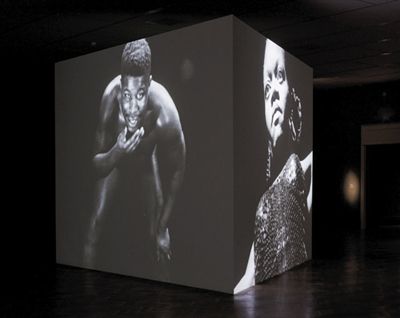 麦奎因早期的三件无声影像作品被投射到了一个三角形的墙面上。其中两面墙上的作品，左边是1993年的《熊》，右边是1995年的《五支歌》。