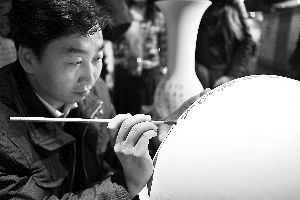 第三届中华民族艺术珍品文化节现场陈四光在瓷瓶上写字。