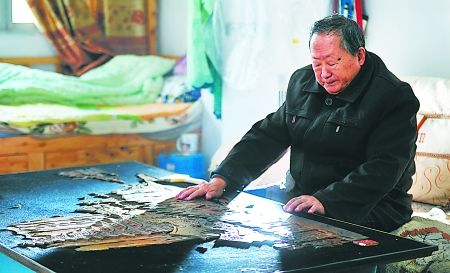 11月22日，忠县，范远万老人独自坐在自己的朽木虫雕作品前沉思。 本组图片由记者 吴珊 摄
