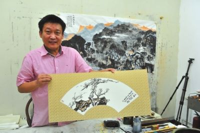 魏广君展示他的扇面新作。京华时报记者陶冉摄