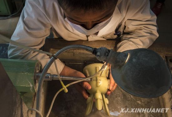 在乌鲁木齐一家玉器雕刻厂车间，姜柏东在对一件玉器斝进行雕琢（4月24日摄）。