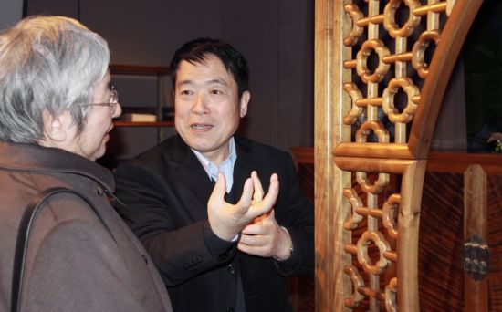 张德祥先生（右）讲解楠木家具艺术