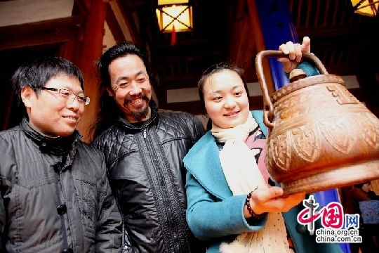 中国网3月35日讯 3月25日，安徽歙县徽州府衙内游客在观赏徽州竹雕大师汪加林（中）的竹雕壶。