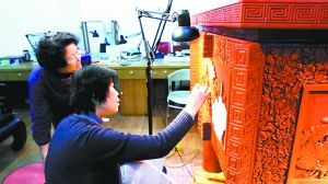 殷秀云（右）在工作室里制作以莲花为主题的雕漆大鼎。 通讯员 张淇摄