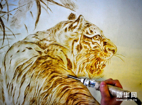 付玉在宣纸上用烙铁绘出一只活灵活现的老虎（2月22日摄）。新华网图片 张超群 摄