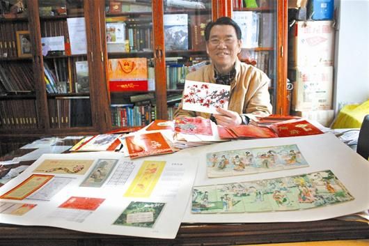 田大网在展示他收藏的年历片及贺年卡 （记者海冰摄）