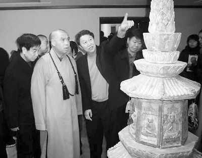 王崇仁（前排左三）向僧人介绍佛舍利五重宝塔