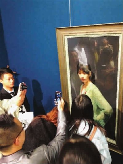 ■ 上海艺博会冷军油画前的观众林明杰 摄