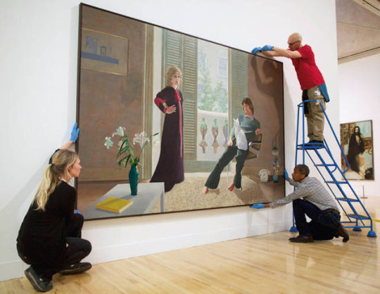 2013年，英国泰特美术馆推出大展“英国艺术500年”。图为工作人员正在布展大卫·霍克尼的代表作《克拉克夫妇和帕西猫》