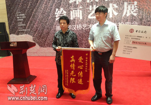 武汉市城管委主任干小明为邱汉桥送上锦旗，表示感谢