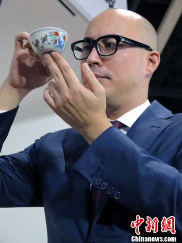 4月8日，在香港苏富比春拍上，玫茵堂珍藏明成化斗彩鸡缸杯以落槌价2.5亿元(港币，下同)、总成交价2.8124亿元拍出，刷新中国瓷器世界拍卖纪录。图为拍卖后，苏富比亚洲区副主席及中国瓷器及工艺品部国际主管仇国仕展示拍品。中新社发 贾思玉 摄 