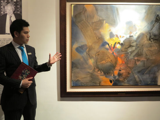 图：郭东杰介绍朱德群的《创世纪》\本报摄