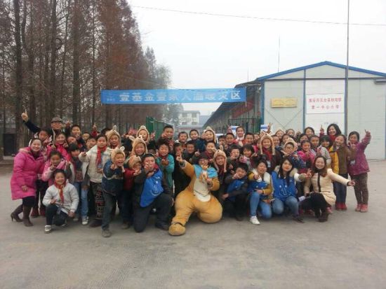 温暖包发放现场工作人员与孩子们合影