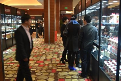 来宾观看陈年名酒，并向工作人员进行咨询