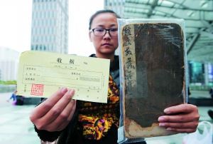 冯小姐出示笔帖和拍卖公司收取服务费时开具的收据。信息时报记者 朱元斌 摄