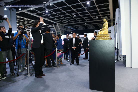 广东中山五觉斋主人郑华星先生（中）于10月8日以创纪录之2亿3,644万港元／3,000美元天价投得明永乐鎏金铜「释迦牟尼佛」坐像，  其艺术顾问─中国少数民族文物保护协会副会长一西平措先生（左）于拍卖后在佛像前顶礼