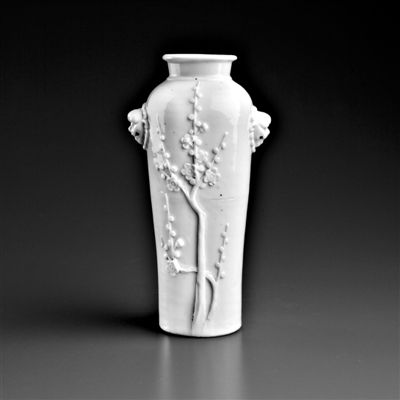 17、18世纪德化白釉堆贴梅纹铺首耳筒式瓶。