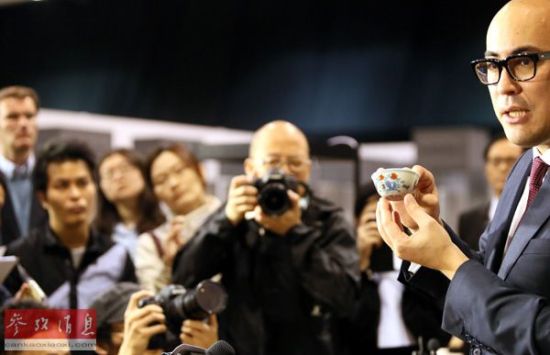 2014年4月8日，苏富比亚洲区副主席仇国仕在拍卖结束后向记者展示成交的明成化斗彩鸡缸杯并回答记者提问。