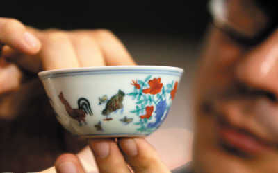 4月8日，苏富比[微博]亚洲区副主席仇国仕在拍卖结束后展示成交的明成化斗彩鸡缸杯