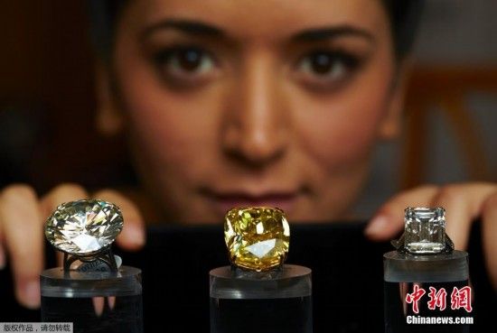 苏富比拍卖行的工作人员在预展上展示三枚即将拍卖的巨型钻石