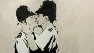 图片</p>

<p>　　这幅作品是从英国海滨城市布莱顿一家酒馆外面的墙壁上移下来的。</p>

<p>　　这一真人大小黑白色彩的涂鸦画描绘正在接吻的两个警察。作品被美国迈阿密一位匿名买家买走。</p>

<p>　　《接吻的警察》是班克西最有名的作品之一。</p>

<p>　　它于2004年喷漆画在布莱顿一家酒馆的侧墙上。</p>

<p>　　班克西多幅画在建筑物上的涂鸦作品已经被挖下卖掉。</p>

<p>　　纽约的一位画商说，他在过去三年中已经售出了11幅班克西的作品。他对《接吻的警察》的拍卖成交价感到满意。</p>

<p>　　2012年英女王登基60周年大庆之前出现在伦敦街头的一幅作品《缝国旗的男孩》后来也被从墙上挪下，并通过这位画商以75万英镑的价格卖给了一名美国收藏家。</p>
<!-- publish_helper_end -->
                 

					<div class=