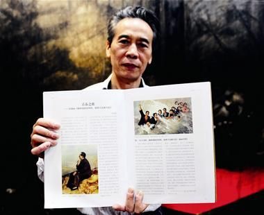 图为：刘柏荣展示载有他画作的图册 记者王永胜摄