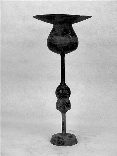 图为龙山文化的蛋壳黑陶龙首镂空高柄杯。