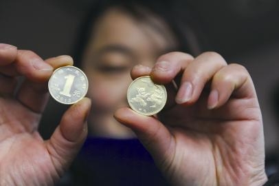 市民向记者展示刚刚兑换到的2013年贺岁普通纪念币