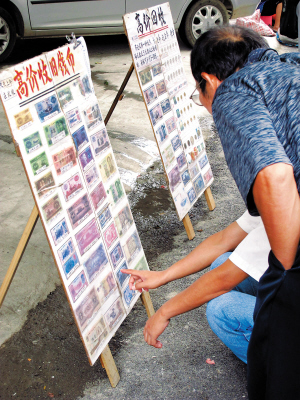 南宁一菜市旁的人民币收购摊，吸引不少市民驻足观看。