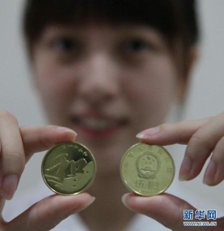 市民小章向记者展示纪念币。